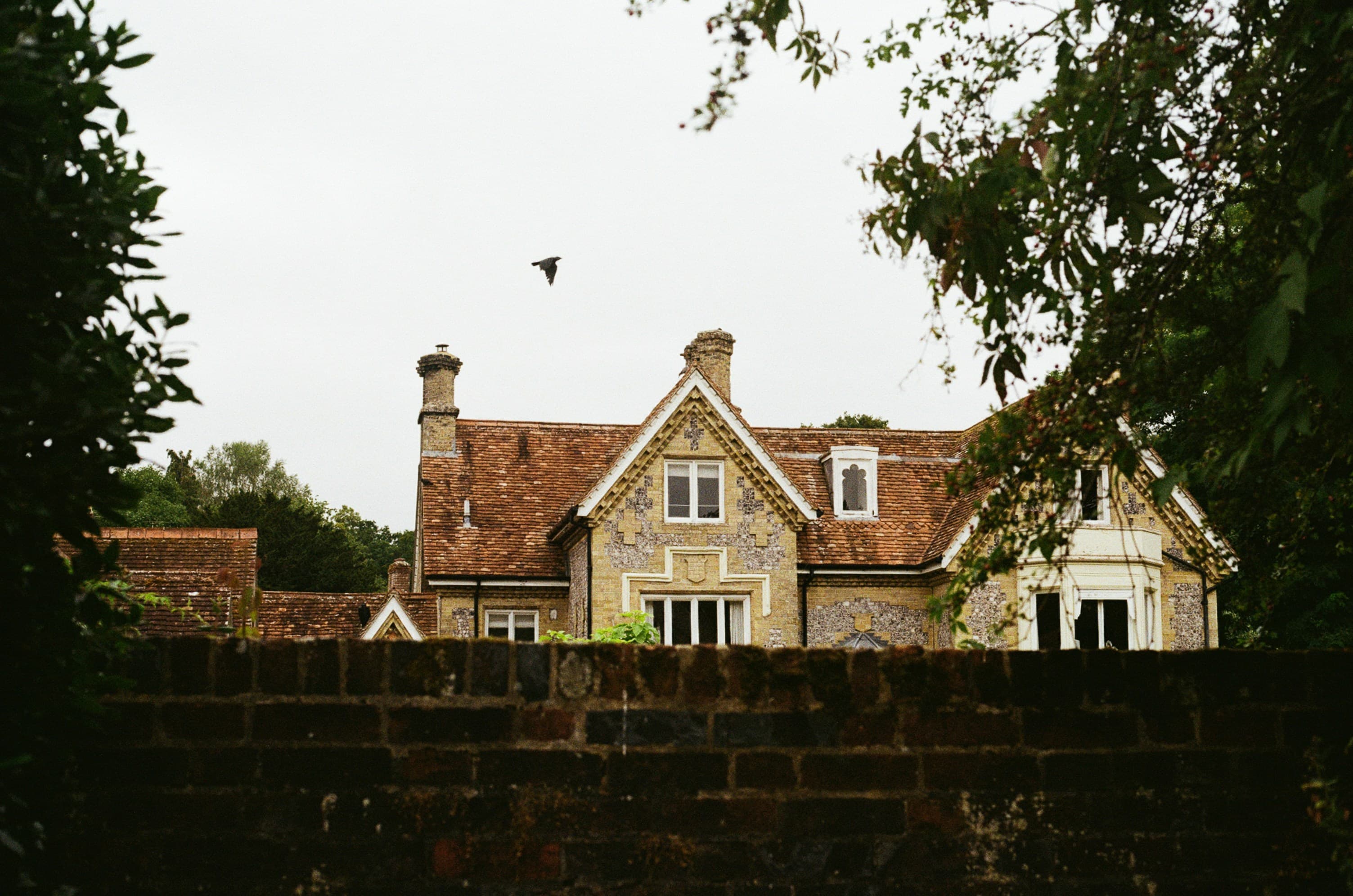 Gothic house viewed over a brick wall